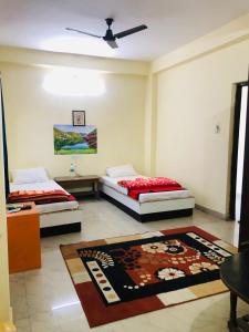 una stanza con due letti e un tappeto di Mahima Guest House a Bodh Gaya Altre 4 foto
