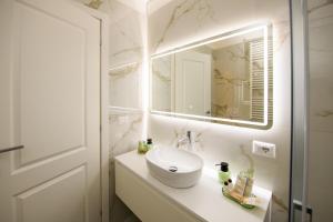 a white bathroom with a sink and a mirror at Boncompagni Serenity Suites in Rome +22 photos