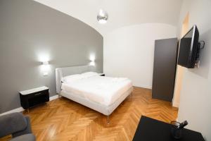 a bedroom with a white bed and a tv at Boncompagni Serenity Suites in Rome