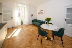 a living room with a table and a green couch at Boncompagni Serenity Suites in Rome