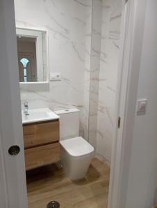 a white bathroom with a toilet and a sink at Casa Jesús in Muxia +19 photos