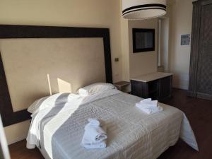 a bedroom with a white bed with towels on it at Hotel OC2 in Rome