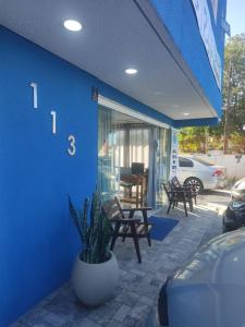 a blue building with a potted plant on a patio at Pousada Kasarão Praia Grande Ubatuba in Ubatuba +92 photos