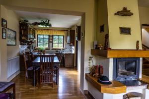 a kitchen and dining room with a table and a fireplace at Janiho Chata Bachledova dolina in Ždiar