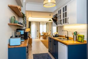 a kitchen with blue cabinets and a living room at Respiro Rooms in Istanbul
