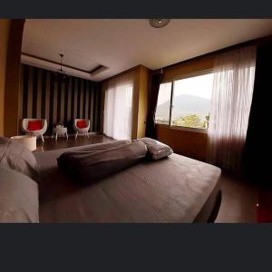 a bedroom with a large bed and a large window at Villa Nadia 8 in Citaringgul 1