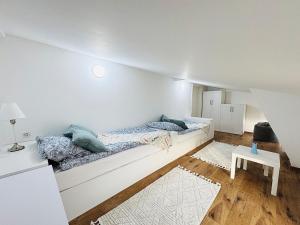 a white room with two beds and a table at Modern Holiday Apartment in Anklam - Next to City Center in Anklam