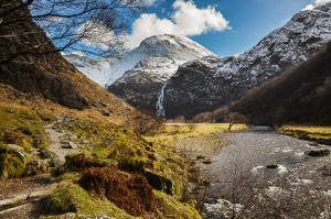 a snow covered mountain with a river in a valley at Rowandell Highland Studio in Fort William