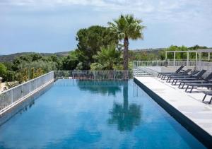 a large swimming pool with chairs and a fence at Tenuta San Marco in Noto