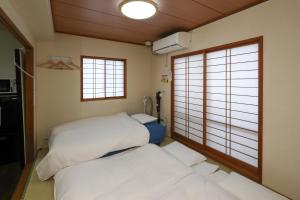 金沢市にあるゲストルーム金沢心音 Guest Room Kanazawa COCONEの窓が2つある部屋にベッドが2つある