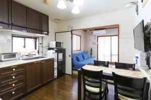 金沢市にあるゲストルーム金沢心音 Guest Room Kanazawa COCONEのキッチン(テーブル、青いソファ付)