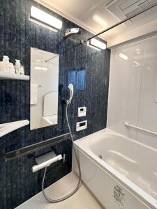un baño con bañera y lavabo en Ikeda Ueno 401 Quad room, en Tokio