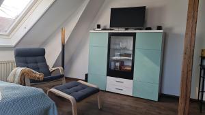 a bedroom with a blue cabinet with a tv on it at Villa Rennerberg in Radebeul