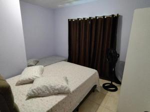 a bedroom with two beds and a black curtain at Apto com jeito de casa entre o mar e a montanha in Florianópolis