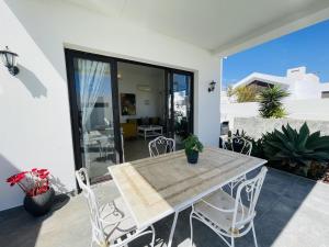 Una mesa de comedor y sillas en el patio de una casa. en Casa Angelita Y Pablo, en Playa Blanca