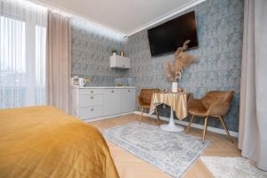 a bedroom with a bed and a table with chairs at Gold Apartments Jacuzzi Room in Częstochowa