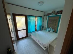 a bedroom with a bed with blue curtains and a window at Il Rifugio sul Mare in Stintino