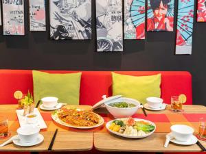 a wooden table with plates of food on it at Ibis Saigon Airport in Ho Chi Minh City