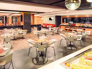 a restaurant with tables and chairs and a buffet at Ibis Saigon Airport in Ho Chi Minh City