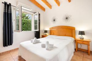 a bedroom with two beds and a window at Villa OCEANA in Cala en Porter +12 photos