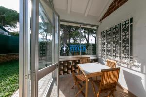 a screened in porch with a table and chairs at Casa Rialto in Lido di Jesolo