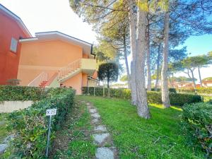 une maison avec un panneau devant une cour dans l'établissement Villaggio Euroresidence, à Bibione