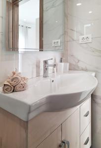 a white bathroom with a sink and a mirror at Coastal Ierapetra 1 in Ierapetra +31 photos