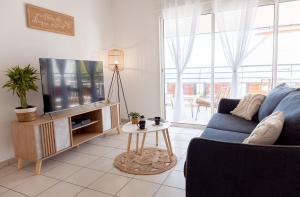 a living room with a blue couch and a tv at Le Petit Coin de LyNa - 3 ÉTOILES - 4 voyageurs in Saint-Pierre
