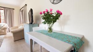 a vase of flowers on a table in a living room at Lavender Lane in George