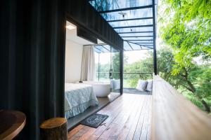 阿拉索亚巴达塞拉Pousada Sunrise Container的一间带浴缸、床和窗户的卧室