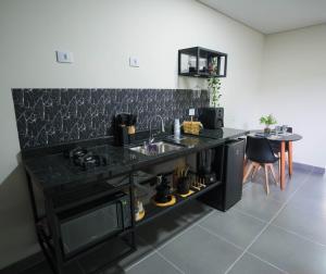a kitchen with a black counter top and a sink at Pousada Sunrise Container in Araçoiaba da Serra