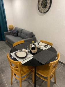 a table and chairs with a table and a couch at Place du bonheur bel appartement f2 in Sarrebourg