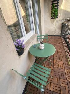 a green table and a chair on a balcony at Place du bonheur bel appartement f2 in Sarrebourg