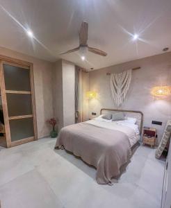 Un dormitorio con una cama y un ventilador de techo. en Apartamento La Tortuga II Beach, en Tarifa