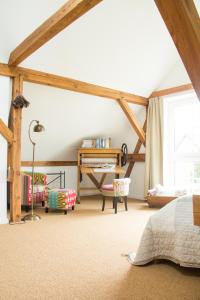 a bedroom with wooden beams and a bed and a table at Ferienhaus Scheune in Reichenwalde