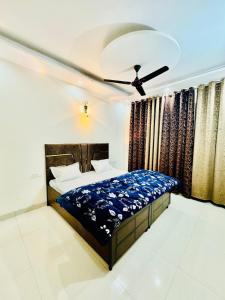 a bedroom with a bed and a ceiling fan at Couples and family welcome for stay in Kharar
