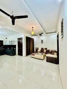a living room with a couch and a ceiling fan at Couples and family welcome for stay in Kharar