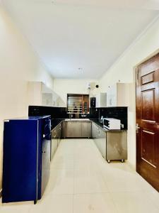 a large kitchen with a blue refrigerator in it at Couples and family welcome for stay in Kharar