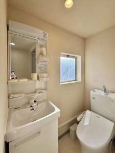 Un baño con lavabo, inodoro y espejo. en Ikeda Ueno 501 Quad room Room, en Tokio