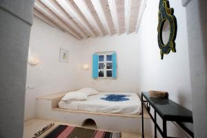 a small bedroom with a bed and a table at Dar Nejma - Djerba Houch in Erriadh