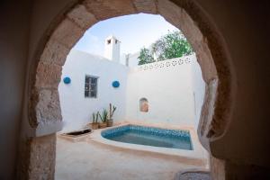 an archway in a building with a swimming pool at Dar Nejma - Djerba Houch in Erriadh