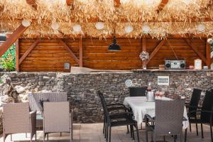 a restaurant with a table and chairs and a stone wall at Ferenc Vendégház in Tihany