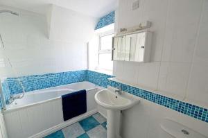 a bathroom with a sink and a tub and a toilet at Old Bakery Cottage in Mortehoe +28 photos