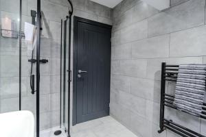 a bathroom with a shower and a black door at Stunning Skyview 2BR flat , fast Wifi - Home Away from Home in Central Station