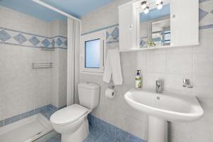 a bathroom with a white toilet and a sink at Haraki Mare Studios Beach Front Apartments in Haraki
