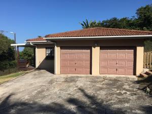 a house with two garage doors in a driveway at Petes Beach House in Port Shepstone