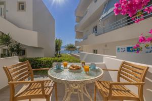 a patio with a table and chairs and a balcony at Haraki Mare Studios Beach Front Apartments in Haraki