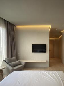 een hotelkamer met een bank en een tv aan de muur bij Chinatown Heritage, Chinatown Main road in Samphanthawong