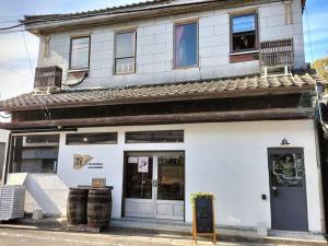 a white building with a sign in front of it at guesthouse横川kito in Kirishima +18 photos