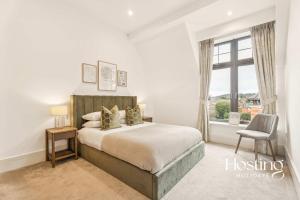 a bedroom with a large bed and a window at The Sovereign Suite - 2-bedroom Luxury Apartment with Parking in Henley on Thames